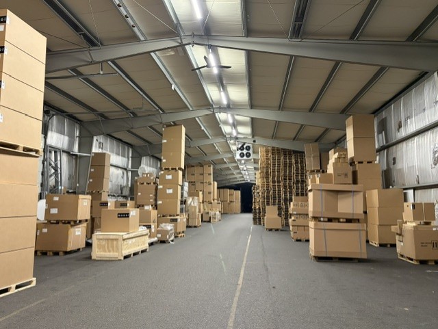 Magazijn van RNDM Production met pallets en dozen klaar voor verzending