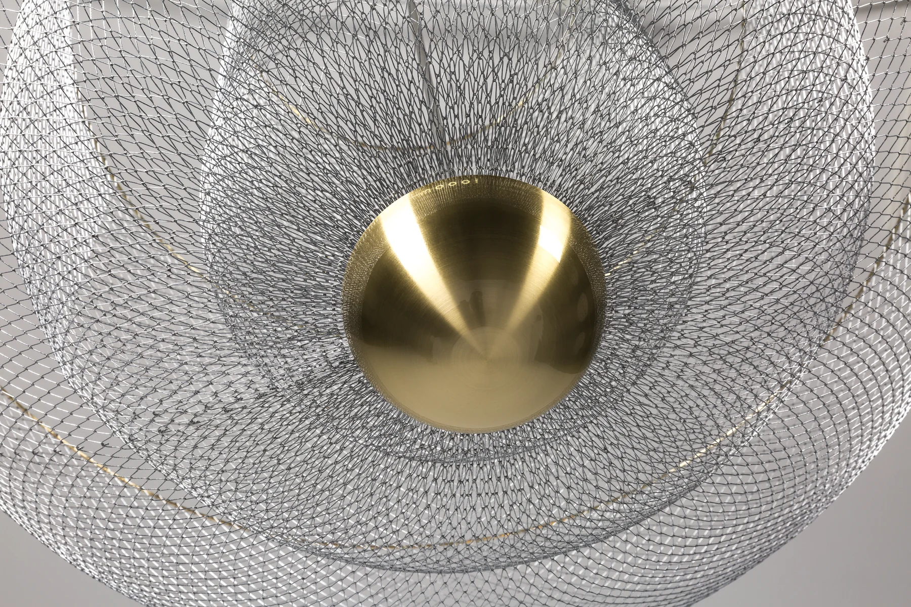 Meshmatics — detail van geweven metaaldraad met messing bol